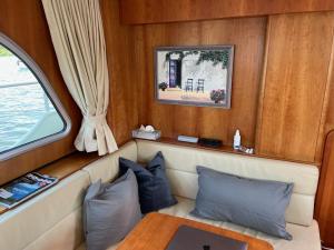 a seat in the back of a boat with a window at Yacht / Hausboot Linssen GS 40.9 AC Abuela in Maasbracht
