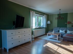 a living room with a white dresser with a television on it at Ferienhaus Lilly in Hain
