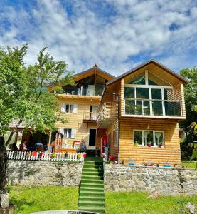 a wooden house with stairs leading up to it at Guesthouse Marashi in Theth