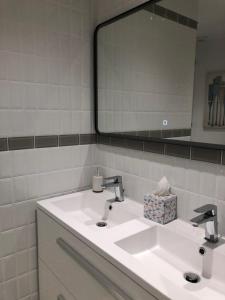 ein Badezimmer mit einem weißen Waschbecken und einem Spiegel in der Unterkunft Gîtes de coussane in Espalion