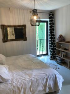 ein Schlafzimmer mit einem weißen Bett und einem Fenster in der Unterkunft Gîtes de coussane in Espalion