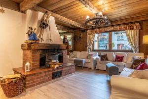 a living room with a brick fireplace and furniture at Hotel Kronplatzer Hof in Rasun di Sopra