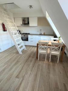 cocina y comedor con mesa y escalera en Moana, en Egmond aan Zee