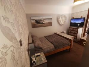 a bedroom with a bed and a tv in it at Tranquillity in Southbourne