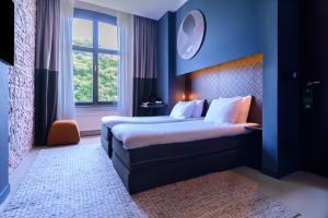 アムステルダムにあるBoutique Hotel Oosteindeのベッド2台と窓が備わるホテルルームです。