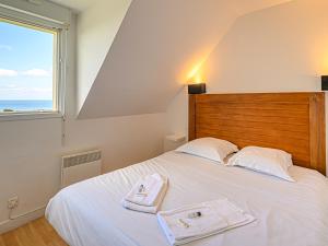 a bedroom with a white bed with two towels on it at Vacancéole - Résidence Les Terrasses de Pentrez-Plage in Pentrez +60 photos