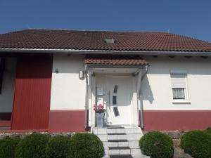 a white and red house with a red roof at Ferienwohnung Lottstetten in Lottstetten