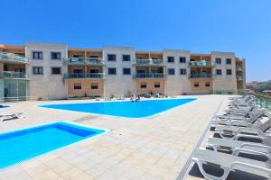 a large swimming pool in front of a building at Hello Summer Studio - Ericeira in Ericeira