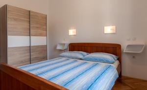 a bedroom with a bed with two blue pillows at Apartments Corny in Pag