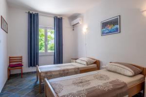 a room with two beds and a window at Apartments Corny in Pag