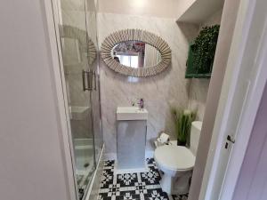 a bathroom with a shower and a toilet and a mirror at Lemur Lodge in Bournemouth