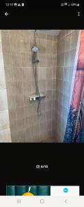y baño con ducha en una pared de azulejos. en H&D Apartment, en Sumartin