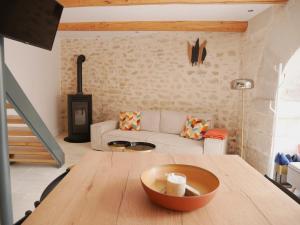 sala de estar con mesa de madera y sofá en Le Clos des Confidences en Grignan