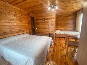 a bedroom with a bed and a desk in a log cabin at Pulmo rest house in Pulʼmo