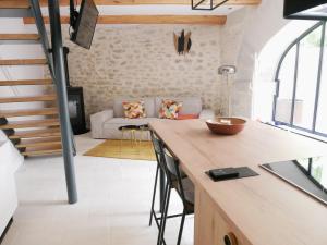 cocina y sala de estar con mesa y sofá en Le Clos des Confidences en Grignan