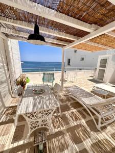 un patio con tavolo, sedie e vista sull'oceano di Casa Solomare by Momò Apulia a Monopoli