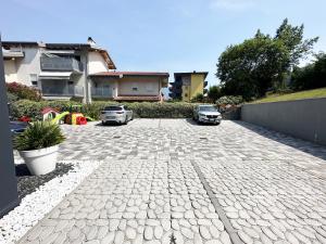 a driveway with two cars parked in front of a house at Residence Zangirolami - Luxury Garden and Balcony Apartments in Riva del Garda