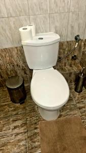 a toilet in a bathroom with two rolls of toilet paper at Anna-Apartment in Nea Moudania