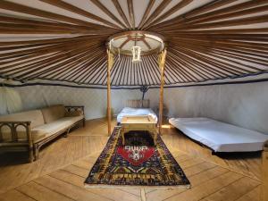 a room with two beds and a rug in a yurt at L'alternatif in Huriel