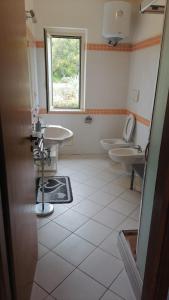 a bathroom with two toilets and a sink and a window at Bilocale RESIDENCE MARASUSA in Parghelia
