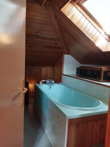 a bathroom with a blue tub in a attic at NOMAD ALP B&B in Marthod