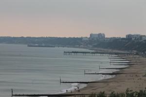 a beach with a pier in the water at Tranquillity in Southbourne