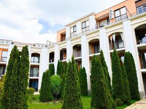 Um edifício com um monte de árvores à frente. em Sea Viev apartments in Sea Fort Club Grand Resort em Elenite