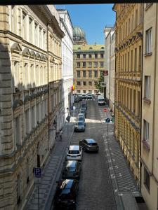 een uitzicht op een straat met geparkeerde auto's bij Le Papillon de Bohème in Praag