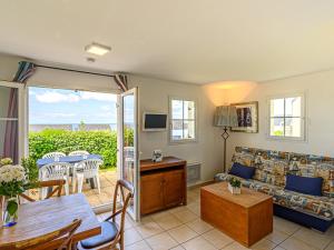a living room with a couch and a table at Vacancéole - Résidence Les Terrasses de Pentrez-Plage in Pentrez