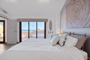 ein weißes Schlafzimmer mit einem großen Bett mit weißen Kissen in der Unterkunft Blue Greenwich Port in Altea