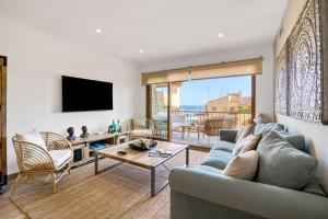 ein Wohnzimmer mit einem blauen Sofa und einem Fernseher in der Unterkunft Blue Greenwich Port in Altea