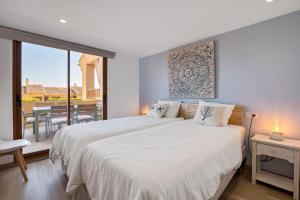 a bedroom with a large white bed and a balcony at Blue Greenwich Port in Altea +19 photos