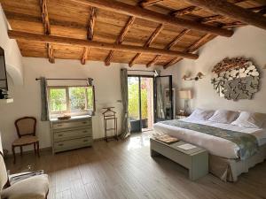 een slaapkamer met een bed, een stoel en een raam bij Hôtel Ambassador Palombaggia in Porto-Vecchio