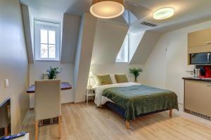 ein kleines Schlafzimmer mit einem Bett und einer Küche in der Unterkunft OVELIA Dijon - Le Courtille Ste-Marthe in Dijon