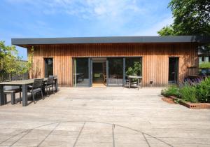 ein Gebäude mit einer Terrasse mit einem Tisch und Stühlen in der Unterkunft Kingswood in Edinburgh