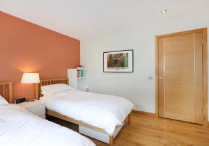 1 dormitorio con 2 camas y puerta en Kingswood en Edimburgo