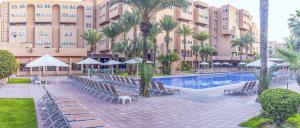 Labranda Rose Aqua Parc في مراكش: منتجع فيه مسبح وكراسي ومبنى