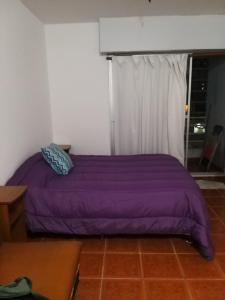 a purple bed in a room with a window at Monoambiente La Boca in Buenos Aires