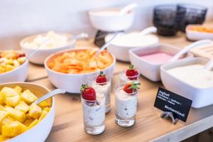 a table topped with bowls of food and desserts at Hotel Krone Churwalden 3 Sterne Superior in Churwalden