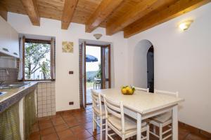 - une cuisine et une salle à manger avec une table et des chaises dans l'établissement Cottage Casale relax e tranquillità, à Gioiosa Marea