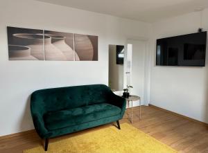 a living room with a green couch and a table at Penzion MOVEINN in Prague