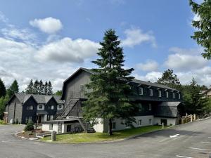 a large black and white house with a tree at Auberge Manitonga in Mont-Tremblant