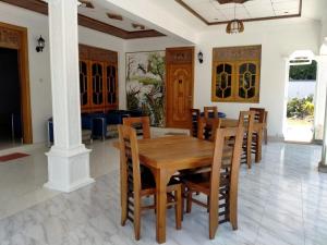 a dining room with a wooden table and chairs at holidays hotel in Dummaladeniya East