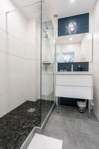 La salle de bains est pourvue d'un lavabo et d'une douche. dans l'établissement L'Exception, sérénité et confort, Evian centre, à Évian-les-Bains
