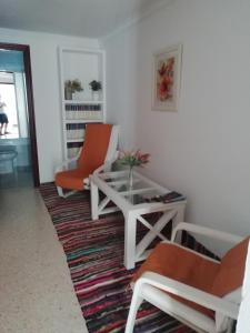 uma sala de estar com duas cadeiras e uma mesa de centro em Apartamento en Duplex em Jerez de la Frontera