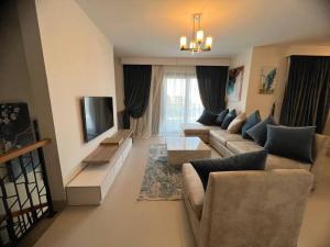a living room with a couch and a television at MKD Marina Residence in El Alamein