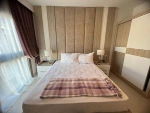 a bedroom with a bed with a plaid blanket on it at MKD Marina Residence in El Alamein