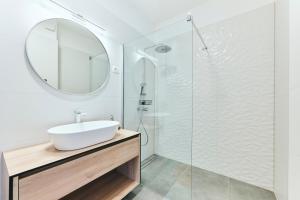 a white bathroom with a sink and a mirror at Apartments San Maris 2 in Umag +33 photos