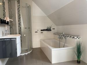 a bathroom with a shower and a tub and a sink at Kellenhusen - Ferienhaus Gabi in Kellenhusen