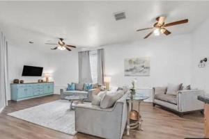 a living room with two couches and a ceiling fan at Beautiful Oasis with rv or boat parking in Las Vegas